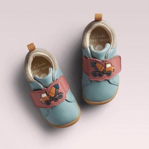 Blue babies shoes with pink straps with a tractor