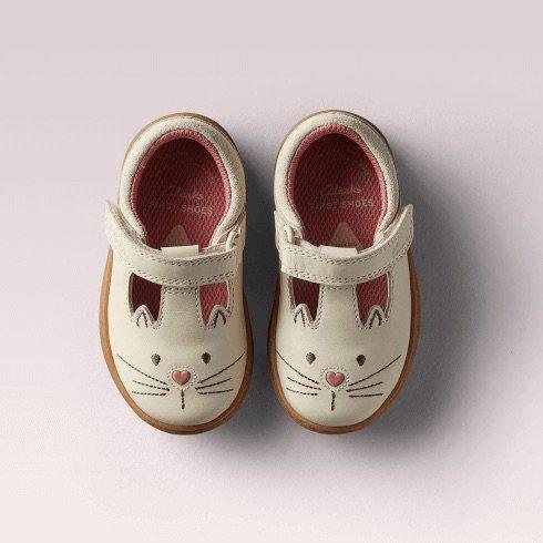 White babies pumps with a cat face on the tip of the shoe