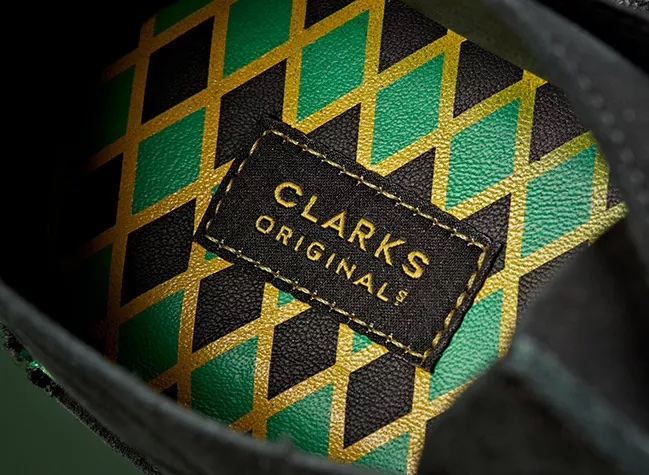 Close-up of the shoe sole which has a jamaican flag pattern with a 'Clarks Orignial' tag stitched in the center.