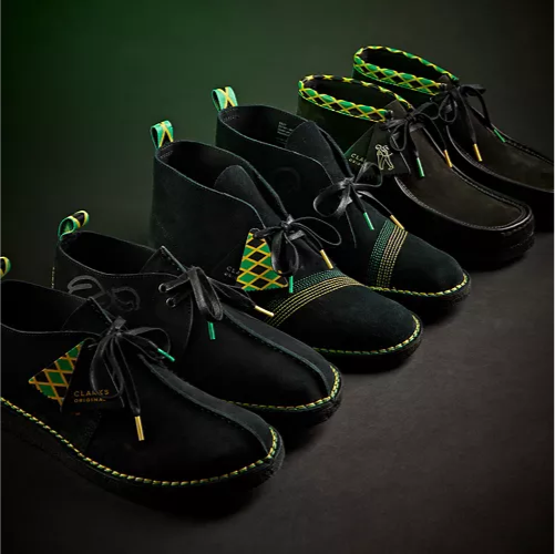 Close-up of a row of three pairs of shoes from the collection on a dark background.