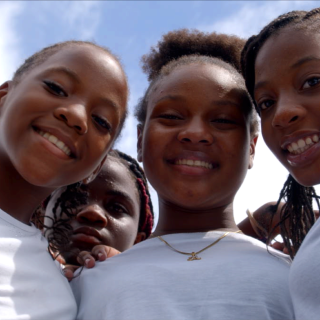 Close-up portrait of overjoyed young students smiling at the camera.